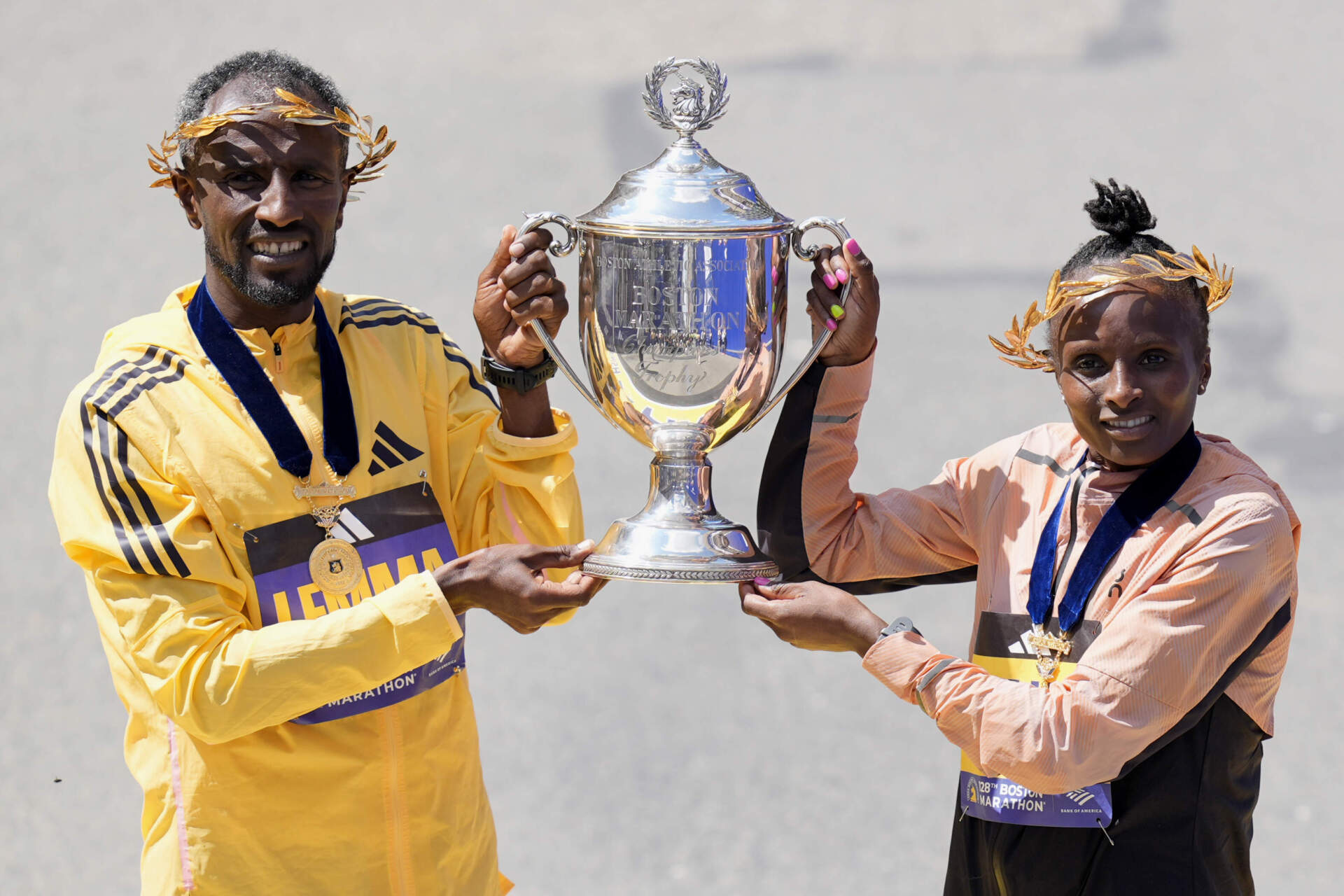 Boston Marathon men's division winner Sisay Lemma, of Ethiopia, left, and women's division winner Hellen Obiri, of Kenya hold up the trophy at the Boston Marathon, Monday, April 15, 2024, in Boston. (AP Photo/Charles Krupa)