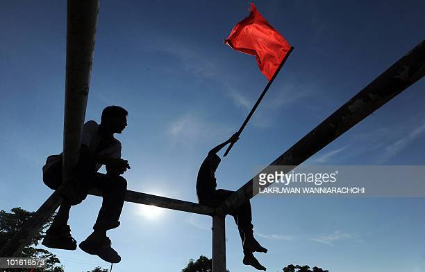 A supporter of the Sri Lankan Marxist JVP or People's Liberation Front waves a red flag during a Labour Day rally in Colombo on May 1, 2010. The JVP is part of the opposition alliance headed by the detained former Army chief General Sarath Fonseka. Sri Lanka's political parties are holding May Day rallies for the first time since the ending of nearly four decades of ethnic bloodshed. Nearly a dozen meetings were scheduled in the capital and suburbs, but labour day celebrations by opposition parties were low-key following their drubbing in two major elections this year. AFP PHOTO/ Lakruwan WANNIARACHCHI (Photo credit should read LAKRUWAN WANNIARACHCHI/AFP via Getty Images)