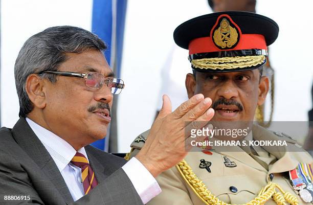 Sri Lankan defence secretary Gotabhaya Rajapakse (L) makes a point as army chief Sarath Fonseka looks on during a felicitation ceremony in Colombo on July 3, 2009.  President Rajapakse and the island's top defence chiefs were felicitated by a Colombo school after security forces crushed the Tamil Tiger rebels and killed chief Velupillain Prabhakaran in mid-May.  AFP PHOTO/Ishara S. KODIKARA (Photo credit should read Ishara S. KODIKARA/AFP via Getty Images)