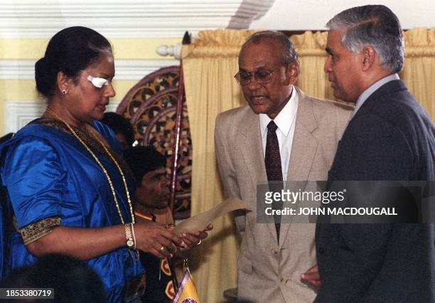 Sri Lankan President Chandrika Kumaratunga (L) takes her oath of office in front of Chief Justice Sarath de Silva (R) and Presidential Secretary Kusumsiri Balapatabendi (C) as she is sworn into office for a second term, 22 December 1999.  Kumaratunga pledged to bring peace with a warning to the members and supporters of the Tamil separatist movement. (Photo by JOHN MACDOUGALL / AFP) (Photo by JOHN MACDOUGALL/AFP via Getty Images)